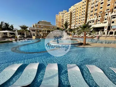 a swimming pool at a resort with a water fountain at Harmony Vacation Homes - BALQIS Residence in Dubai