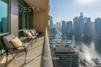 a balcony with chairs and a view of a river at Al Majara by EMAAR, Dubai Marina in Dubai
