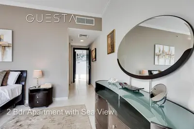 a mirror in a room with a bed and a desk at Al Majara by EMAAR, Dubai Marina in Dubai