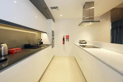 a white kitchen with a long counter and a sink at New Arabian Luxury 2 Bedroom In Blue Water in Dubai