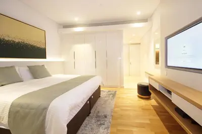 a bedroom with a large bed and a flat screen tv at New Arabian Luxury 2 Bedroom In Blue Water in Dubai