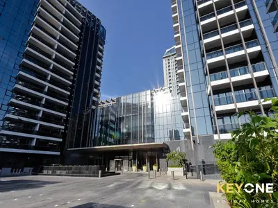 a large glass building with two tall buildings at Sophisticated One Bedroom with Full Marina View in Dubai