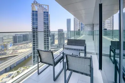 two chairs on a balcony with a view of the city at Maison Privee - Luxury, Spacious, Modern Near Burj Khalifa and Dubai Canal in Dubai
