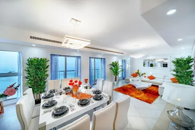 a dining room and living room with a table and chairs at Princess Tower highest world Penthouse floor 86! in Dubai