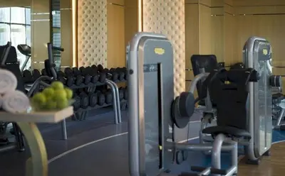a gym with dumbbells and a table with a bowl of fruit at HotelApart Dubai Mall st Burj Khalifa View in Dubai
