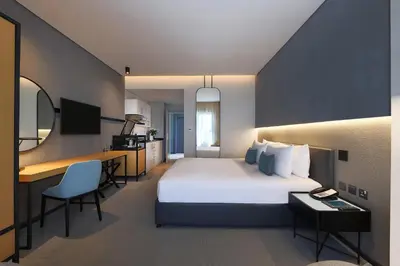 a hotel room with a bed and a desk at JA The Manor Hotel, Dubai in Dubai