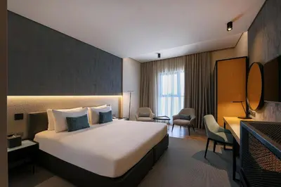 a hotel room with a large bed and a desk at JA The Manor Hotel, Dubai in Dubai
