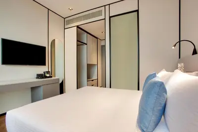 a bedroom with a large white bed and a tv at Lemon Tree Hotel, Jumeirah Dubai in Dubai