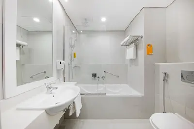 a white bathroom with a tub and a sink at Citymax Hotel Business Bay in Dubai