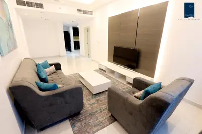 a living room with two couches and a flat screen tv at Samaya Hotel Apartment Dubai in Dubai