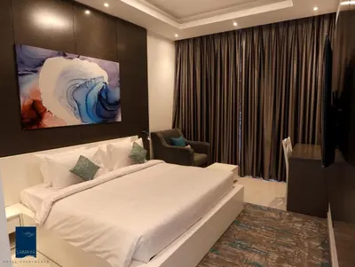 a hotel room with a bed and a chair at Samaya Hotel Apartment Dubai in Dubai