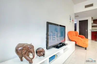 a living room with a flat screen tv on a counter at Community Vibe Living with Wellness Access Close to Metro, Mediterranean, Discovery Gardens by Deluxe Holiday Homes in Dubai