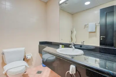a bathroom with a toilet and a sink at Community Vibe Living with Wellness Access Close to Metro, Mediterranean, Discovery Gardens by Deluxe Holiday Homes in Dubai