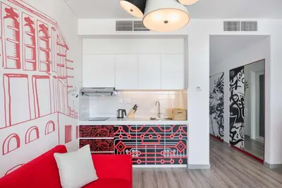 a living room with a red couch and a kitchen at Radisson RED Dubai Silicon Oasis in Dubai