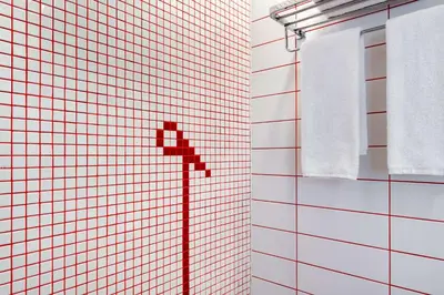 a bathroom with white towels and a red cross on the wall at Radisson RED Dubai Silicon Oasis in Dubai