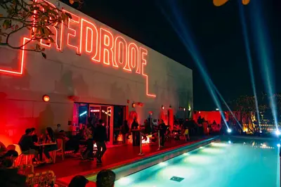 a group of people standing around a swimming pool at night at Radisson RED Dubai Silicon Oasis in Dubai