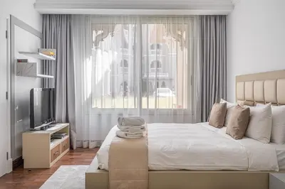 a bedroom with a large bed and a television at HiGuests - Luxurious 1BR in Palms with Private Beach Access in Dubai