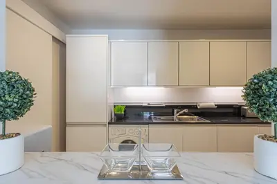 a kitchen with white cabinets and a marble table at HiGuests - Luxurious 1BR in Palms with Private Beach Access in Dubai