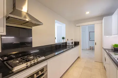 a kitchen with white cabinets and a stove top oven at HiGuests - Luxurious 1BR in Palms with Private Beach Access in Dubai