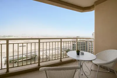 a balcony with a table and chairs and a view of the beach at GuestReady Holiday Homes - Sunny Delights in Dubai