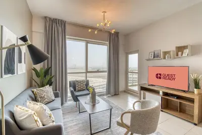 a living room with a couch and a tv at GuestReady Holiday Homes - Sunny Delights in Dubai