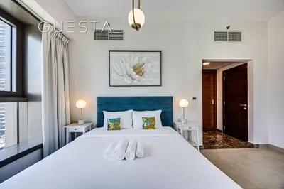 a bedroom with a large white bed with two white towels at Sparkle Tower, Dubai Marina in Dubai