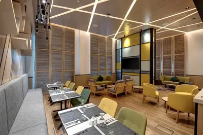 a restaurant with tables and chairs and a tv at URBAN Al Khoory Hotel in Dubai