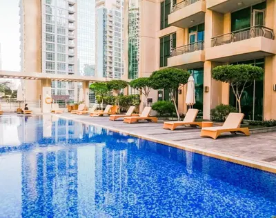 a hotel swimming pool with lounge chairs and buildings at Westminster Boulevard Central - Burj Khalifa in Dubai