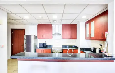 a kitchen with wooden cabinets and a counter top at 1 Bedroom with Stunning Ain Dubai and Full Sea View in Dubai