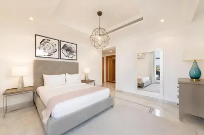 a white bedroom with a bed and a window at Maison Privee - Luxury Villa with Dramatic View Private Beach & Pool in Dubai