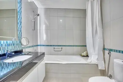 a bathroom with a tub and a sink and a toilet at Ultra modern 1BD in Damac Heights Marina in Dubai