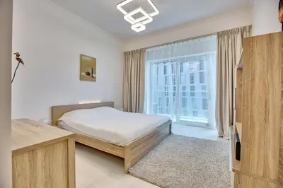 a bedroom with a bed and a large window at Ultra modern 1BD in Damac Heights Marina in Dubai