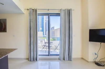 a living room with a sliding glass door with a balcony at Bay Central 1BD apartment with awesome Marina view in Dubai