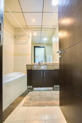 a bathroom with a tub and a sink and a mirror at Bay Central 1BD apartment with awesome Marina view in Dubai