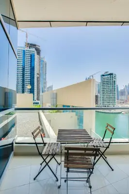 a table and chairs on a balcony with a view of the city at Bay Central 1BD apartment with awesome Marina view in Dubai
