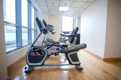 a gym with cardio machines in a room with windows at Bay Central 1BD apartment with awesome Marina view in Dubai