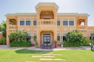 a large orange building with a table in the yard at Maison Privee - Prvt Pool & Beach Access in Luxury Palm Jumeirah 6BR Villa in Dubai