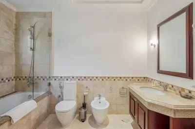 a bathroom with a toilet and a sink and a tub at Maison Privee - Prvt Pool & Beach Access in Luxury Palm Jumeirah 6BR Villa in Dubai