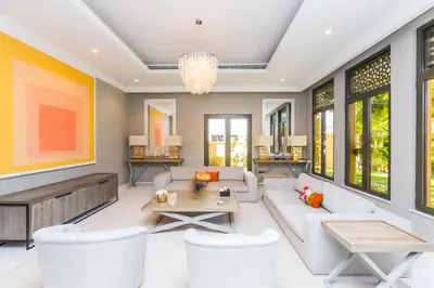 a living room with white furniture and a chandelier at Maison Privee - Prvt Pool & Beach Access in Luxury Palm Jumeirah 6BR Villa in Dubai