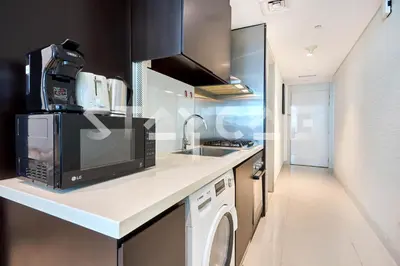 a kitchen with a microwave and a washer and sink at Staycae Holiday Homes - Upper Crest in Dubai