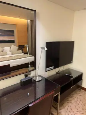 a bedroom with a desk with a bed and a large mirror at Address Dubai Mall Fashion Avenue 1 bedroom 34 floor in Dubai