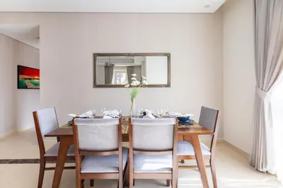 a dining room with a table with chairs and a mirror at Frank Porter - Mon Reve in Dubai