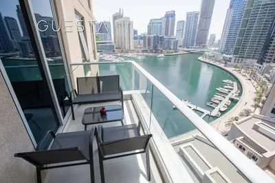 a balcony with chairs and a view of a river at Marina Promenade - Paloma Tower, Dubai Marina in Dubai