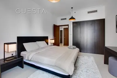 a bedroom with a large bed and a desk at Marina Promenade - Paloma Tower, Dubai Marina in Dubai