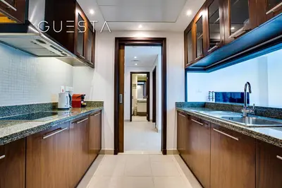 a kitchen with wooden cabinets and a sink at Marina Promenade - Paloma Tower, Dubai Marina in Dubai