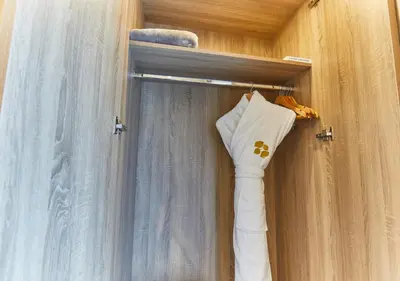 a closet with a curtain and a white shirt hanging at Rose Plaza Hotel Al Barsha in Dubai