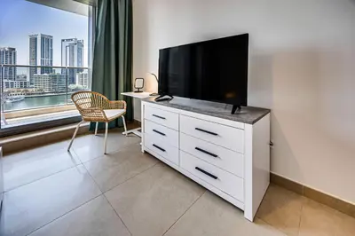 a white dresser with a flat screen tv on top of it at 5 star Sparkle Tower by Swarovski, Dubai Marina in Dubai