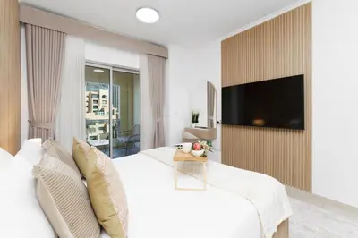 a bedroom with a large bed with a tv on a wall at Maison Privee - Exclusive Duplex Villa with Panoramic Terrace Overlooking Burj Khalifa in Dubai
