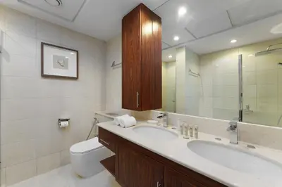 a bathroom with a sink and a toilet and a mirror at Maison Privee - Exclusive Duplex Villa with Panoramic Terrace Overlooking Burj Khalifa in Dubai
