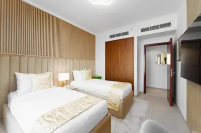 a hotel room with two beds and a television at Maison Privee - Exclusive Duplex Villa with Panoramic Terrace Overlooking Burj Khalifa in Dubai